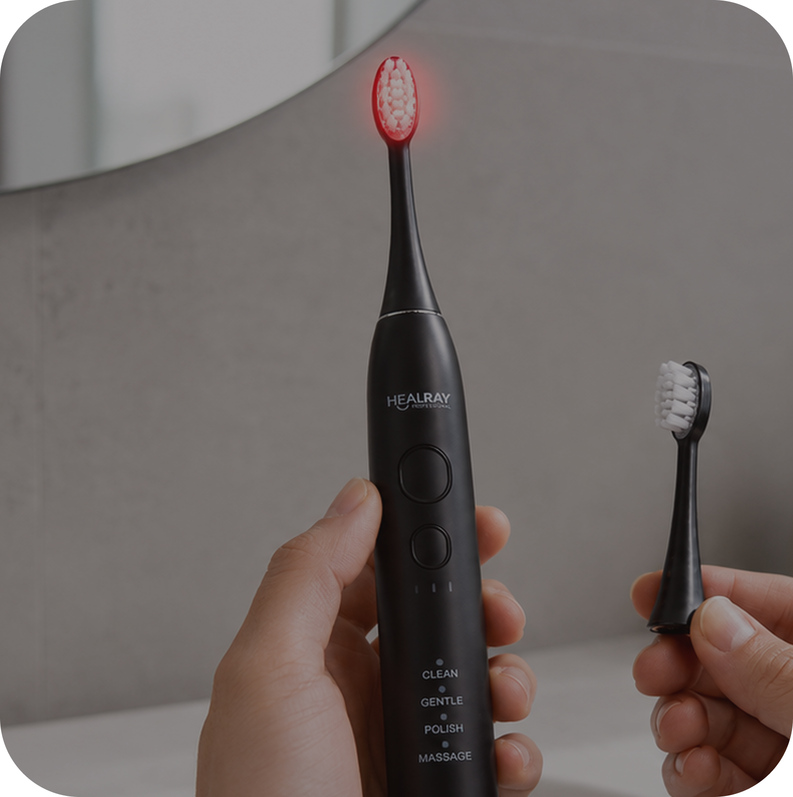 Hand holding the HealRay light therapy toothbrush with a replacement head